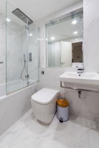 Baño blanco con aseo y lavamanos en Stylish 1 bedroom apartment in Maida Vale en Londres