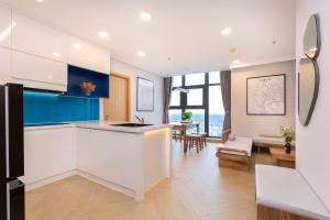 a kitchen with white cabinets and blue accents at Căn Hộ Vũng Tàu in Xa Thang Nhut