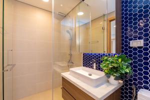 a bathroom with a sink and a glass shower at Căn Hộ Vũng Tàu in Xa Thang Nhut +8 photos