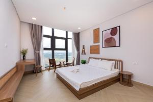a bedroom with a bed and a desk and a window at Căn Hộ Vũng Tàu in Xa Thang Nhut