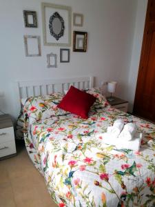 a bed with a red pillow and towels on it at CASA DIEGO PUERTO BLANQUILLO in Frigiliana
