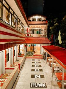 a building with a red roof with a table and benches at Mario's Travellers Inn in Coron