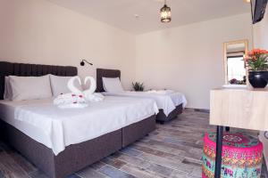 two beds with stuffed animals on them in a room at JULİETOTEL in Alacati