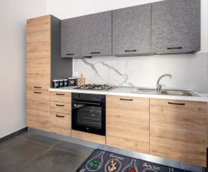 a kitchen with wooden cabinets and a stove and a sink at Sogni d'estate in Avola