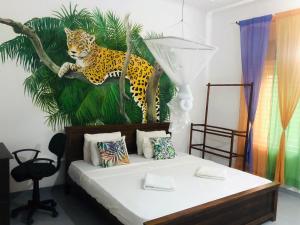 um quarto com uma cama com uma pintura de um leopardo em Anilau Vila em Hikkaduwa