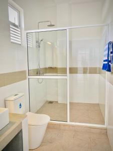 ein weißes Bad mit einer Dusche und einem WC in der Unterkunft Sevenra Grand Beach Hotel in Ambalangoda