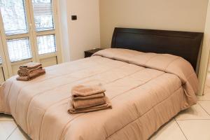 a bedroom with a large bed with two towels on it at Casa Giulia in Cuneo