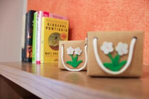 due tazze di caffè sedute su uno scaffale con libri di Casa Giulia a Cuneo