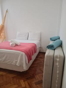 a small bedroom with a bed and a ottoman at charmoso vista mar apê copa 80 metros da praia in Rio de Janeiro