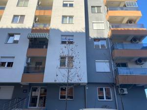 an apartment building with a tree in front of it at srle home in Skopje
