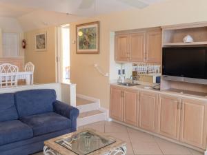 uma sala de estar com um sofá azul e uma televisão em Deluxe Ocean View Villas - Just Steps From White Sand Beaches em Creek Village