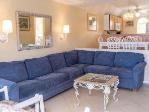 a blue couch in a living room with a table at Deluxe Ocean View Villas - Just Steps From White Sand Beaches in Creek Village