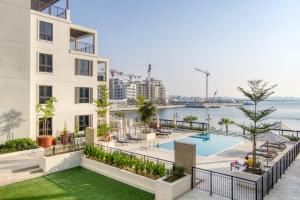 an image of a building with a swimming pool at Spacious 2BR flat, La Rive 2 in Dubai