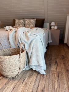 a bedroom with a bed with a blanket and a basket at Pine & Oak Holiday Home in Fužine
