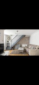 a living room with a couch and a staircase at Beautiful Views Welsh Valley home in Mountain Ash