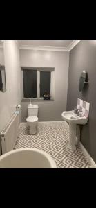 a bathroom with a tub and a toilet and a sink at Beautiful Views Welsh Valley home in Mountain Ash