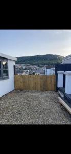 un balcón de una casa blanca con una valla de madera en Beautiful Views Welsh Valley home en Mountain Ash