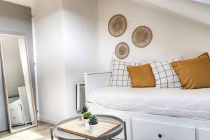 a white bedroom with a bed and a table at Nantes Central & Confort in Nantes