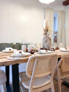 uma mesa de jantar com pratos brancos e cadeiras em Pine & Oak Holiday Home em Fuzine