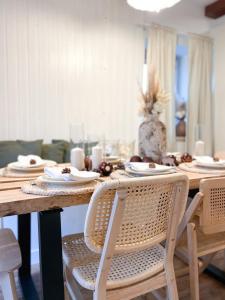 a dining room table with white plates and chairs at Pine & Oak Holiday Home in Fužine