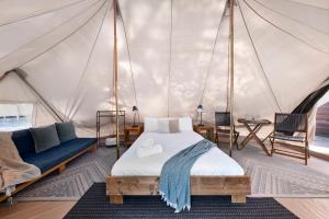 um quarto com uma cama numa tenda em Scamander Sanctuary Holiday Park em Scamander