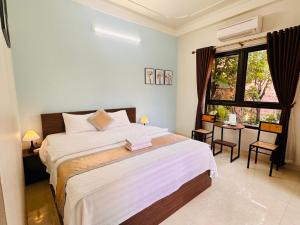 a bedroom with a large bed and a window at Tam Coc Elegance House in Ninh Binh