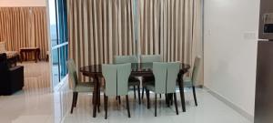 uma sala de jantar com uma mesa de madeira e cadeiras verdes em Royal Nest Premium-AS em Pune
