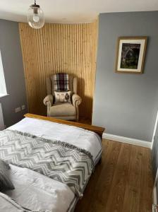 ein Schlafzimmer mit einem Bett und einem Stuhl darin in der Unterkunft Old Canal-Side Cottage Taff Trail Merthyr Tydfil in Abercanaid