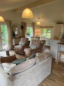 a living room with a large couch and chairs at Waterside Lodge, Weybourne, Holt in Weybourne