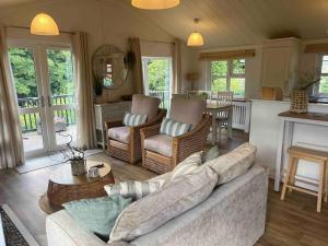 a living room with a couch and a table at Waterside Lodge, Weybourne, Holt in Weybourne