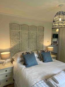 a bedroom with a large white bed with blue pillows at Waterside Lodge, Weybourne, Holt in Weybourne