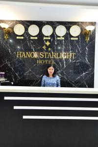 una foto de una mujer parada frente a los relojes en Hanoi Starlight Boutique Hotel, en Hanói
