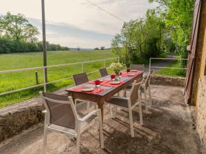 a table and chairs on a patio with a view of a field at Holiday home with swimming pool in Saint-Laurent-la-Vallée