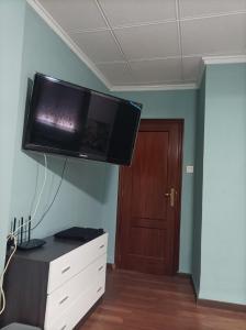 TV de pantalla plana colgada del techo de una habitación en Habitación Villena lavanda, en Villena