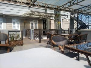 een patio met tafels en stoelen en een grill bij Lux Suites Narok Holiday Homes in Narok