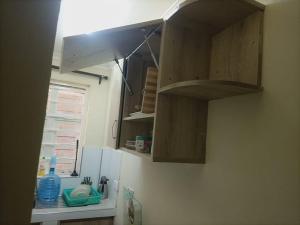 een keuken met houten kasten en een wastafel bij Lux Suites Narok Holiday Homes in Narok
