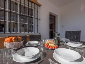 una mesa con platos blancos y una cesta de comida en La Fonda de Julia Magnifica casa muy luminosa y amplia con chimenea y barbacoa, en Matalascañas