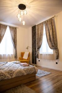 una camera da letto con un letto, una sedia e finestre di Apartment Serdika 1 a Sofia