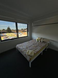 1 dormitorio con cama y ventana grande en Comfortable bedroom in a beautiful suburb, en St Albans