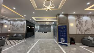 um átrio com sofás e um bar num edifício em قمم بارك النماص Qimam Park Hotel 6 em Al Namas
