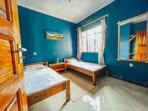 um quarto com 2 camas e uma parede azul em Adventurous’home em Moshi