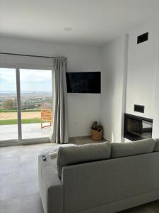 a living room with a couch and a large window at Mirador el atardecer in Cádiz