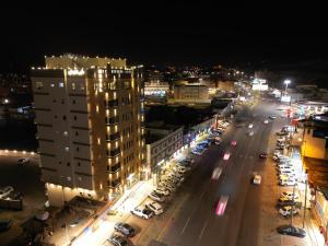 قمم بارك النماص Qimam Park Hotel 6 في النماص: شارع المدينة بالليل فيه سيارات ومباني