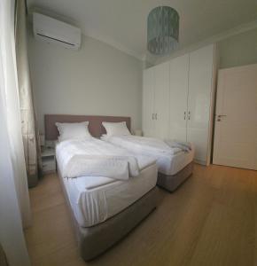 a bedroom with two beds with white sheets at Tsar Asen 21 in Sofia