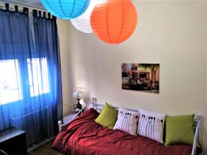 ein Schlafzimmer mit einem Bett mit orangefarbenen und grünen Kissen in der Unterkunft monokatoikia ston lagkada in Langadas