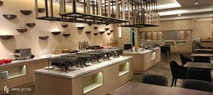 ein Restaurant mit einer großen Küche mit Tischen und Stühlen in der Unterkunft Amverton Heritage Resort in Malakka