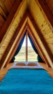 - un lit dans un grenier en bois avec une fenêtre dans l'établissement HelenaHouse22, à Ledinci