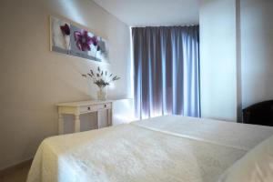 a white bedroom with a bed and a window at Hotel Bruc in El Bruc