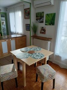 a kitchen with a wooden table and two chairs at Charmant 3 pièces 10 min de Lyon in Villeurbanne