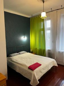 a green bedroom with a bed with a red towel on it at Hostel Retro in Kraków